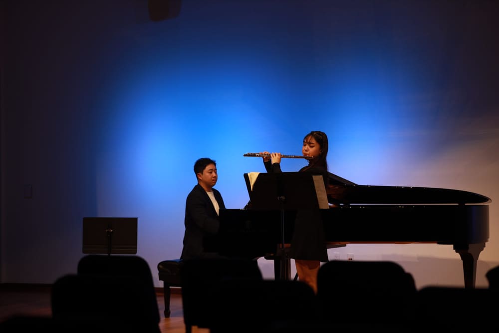 Monica and a pianist performing on a blue-lit stage