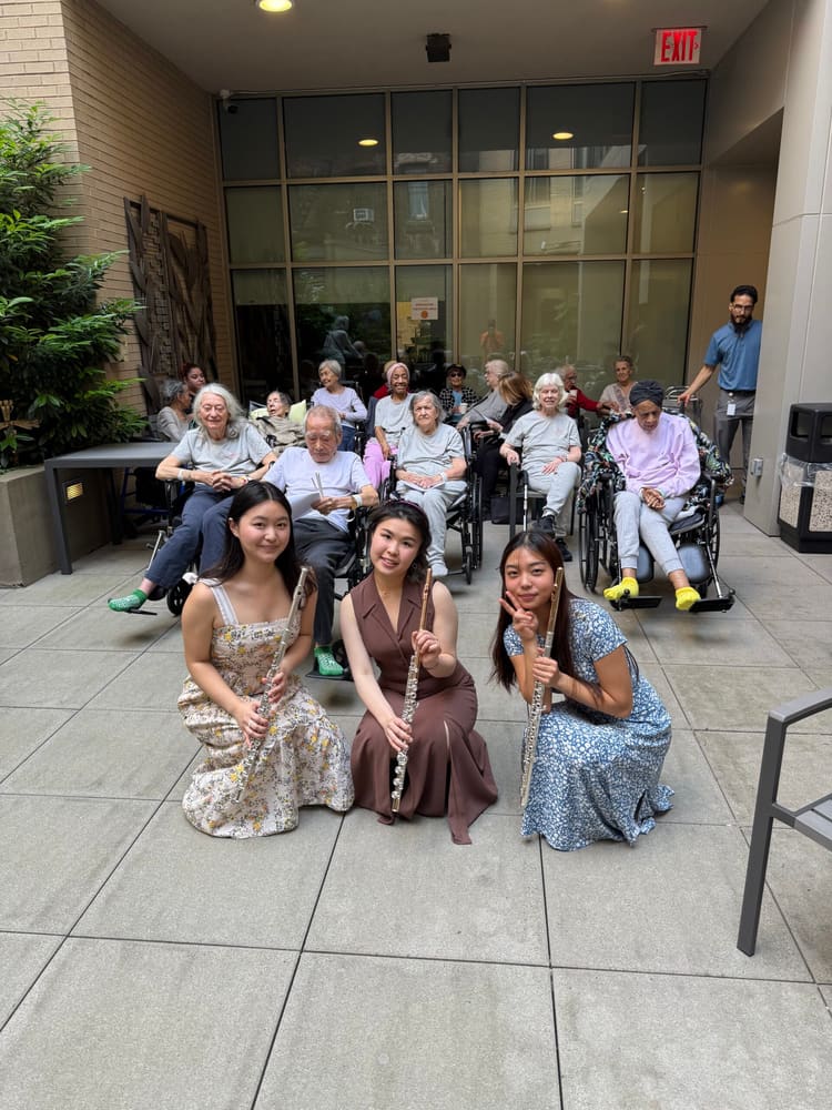 Flutists with an audience in a courtyard after a performance